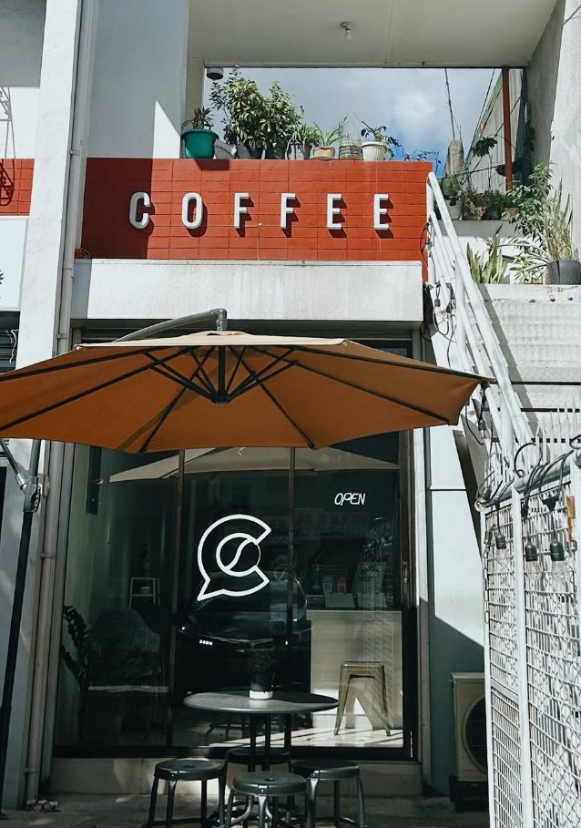 Coze Coffee storefront with a red tiled COFFEE sign and an orange patio umbrella